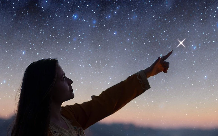 A woman silhouetted against a star-filled sky, pointing at one star