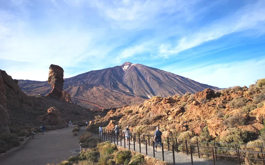 A stone-paved viewing path leading towards the rock pillar and the Teide cone