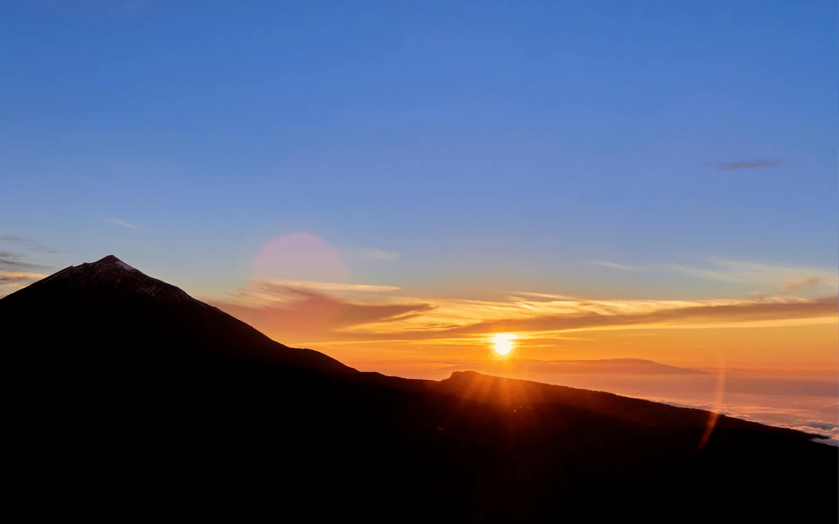 The cone of Mount Teide above a sea of clouds at sunset
