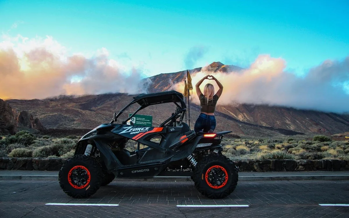 A line of buggies on a mountain track above the clouds in the evening light